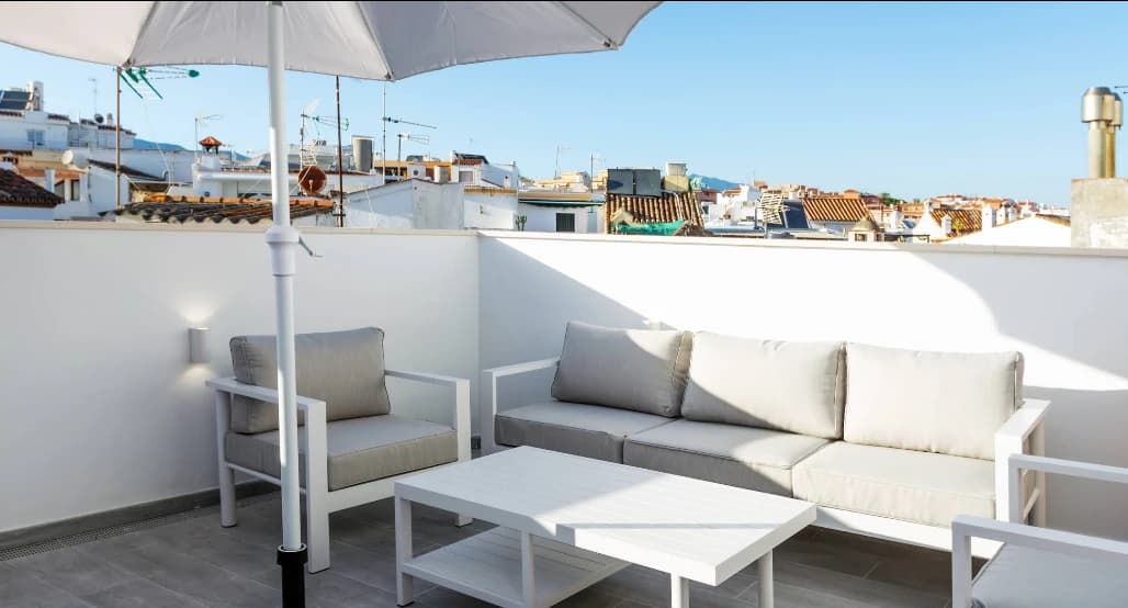 Cushioned sofa seating on a sunny rooftop above the old town at The Old Town Hotel, Estepona