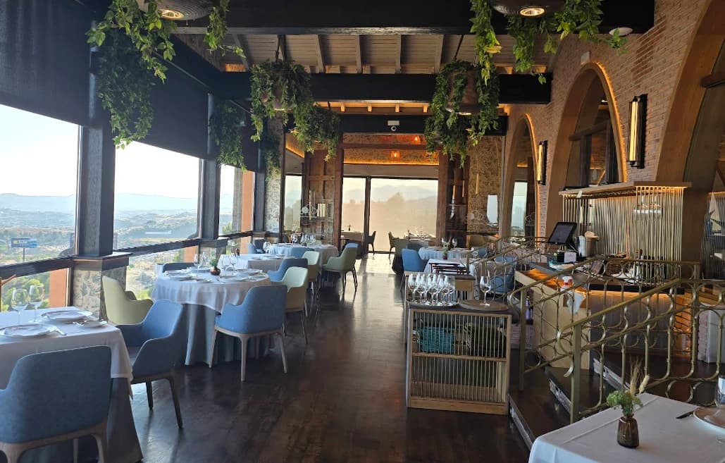 Set tables under hanging greenery overlooking the valley at El Higueron, Fuengirola