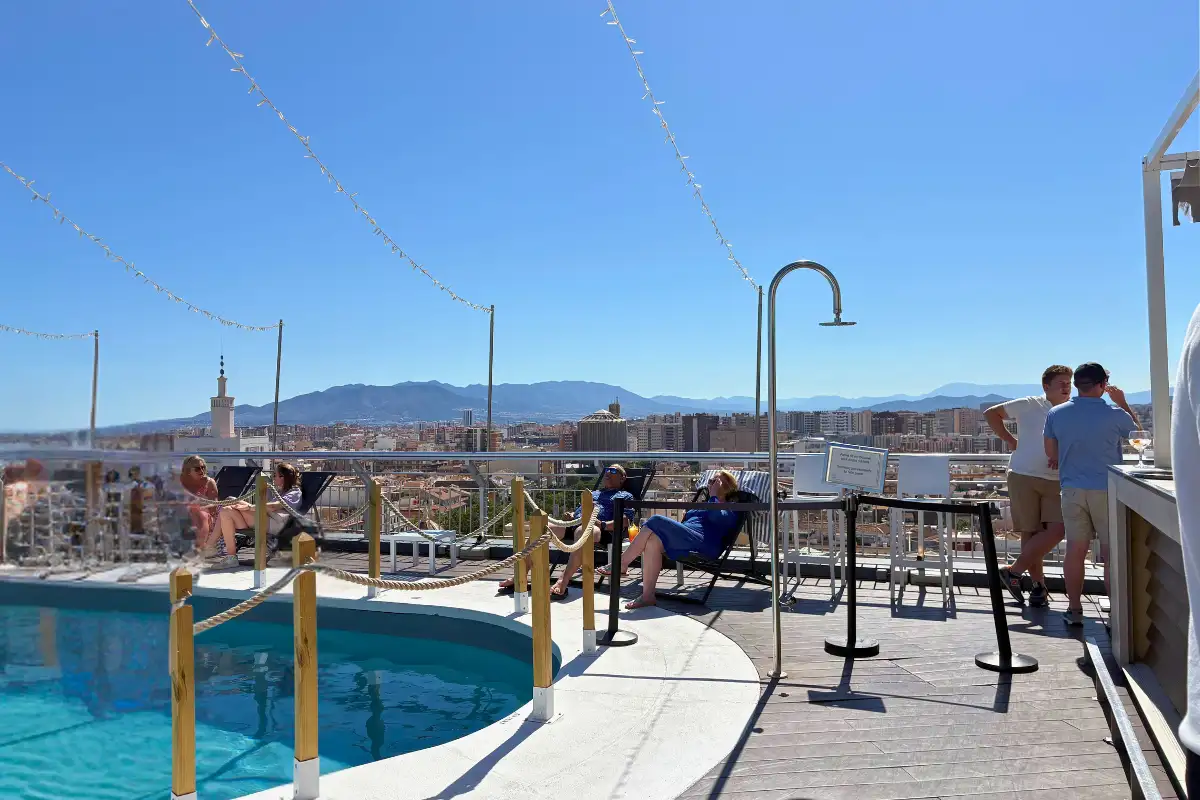 Rooftop pool with city and mountain views at AC Hotel Malaga Palacio