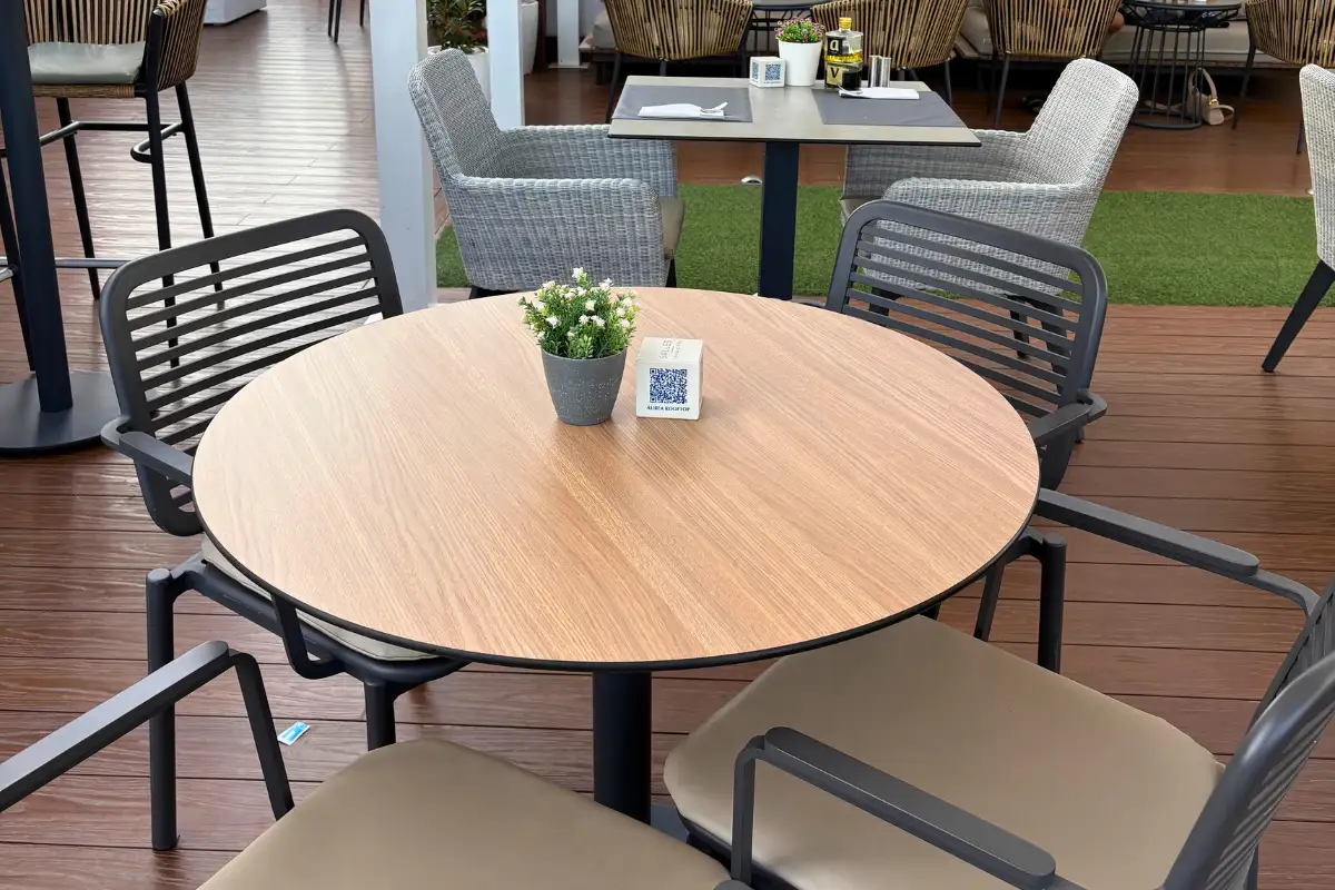 Round wooden dining table and chairs on Aurea rooftop terrace in Malaga