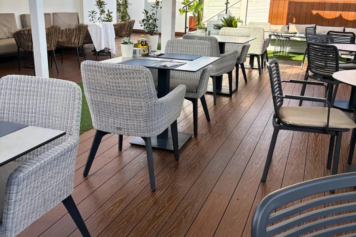 Woven dining chairs and tables on the Aurea terrace in Malaga