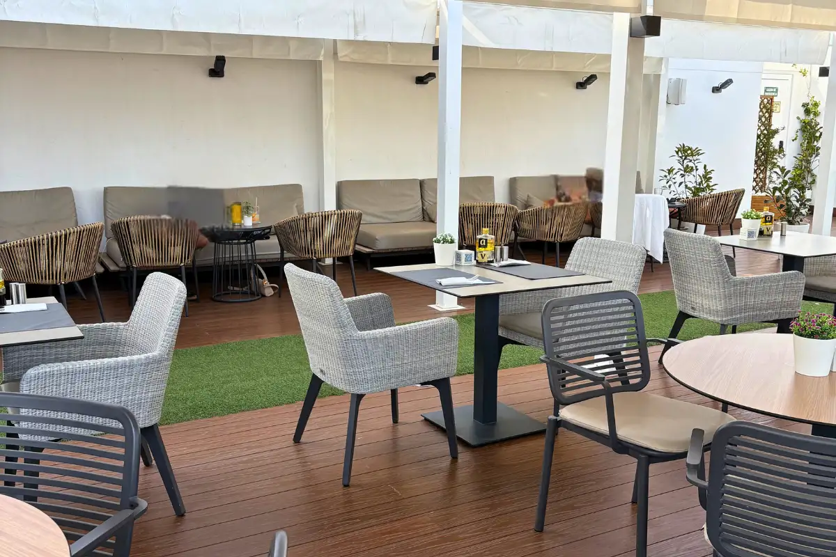 Lounge sofas and dining tables under the pergola at Aurea Malaga
