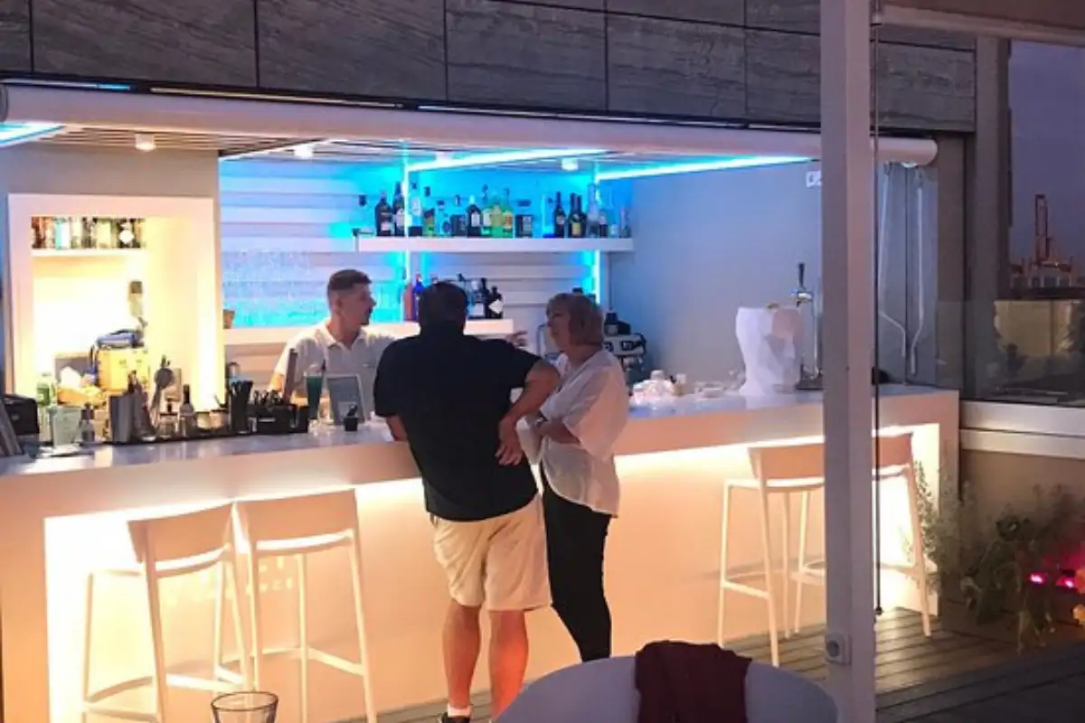 Guests at the lit cocktail bar at night on the B-Heaven rooftop Malaga