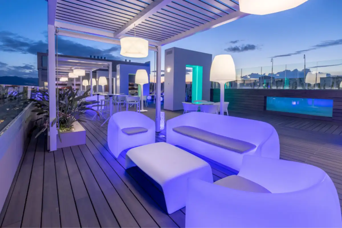 Glowing white lounge furniture at dusk on the B-Heaven terrace in Malaga