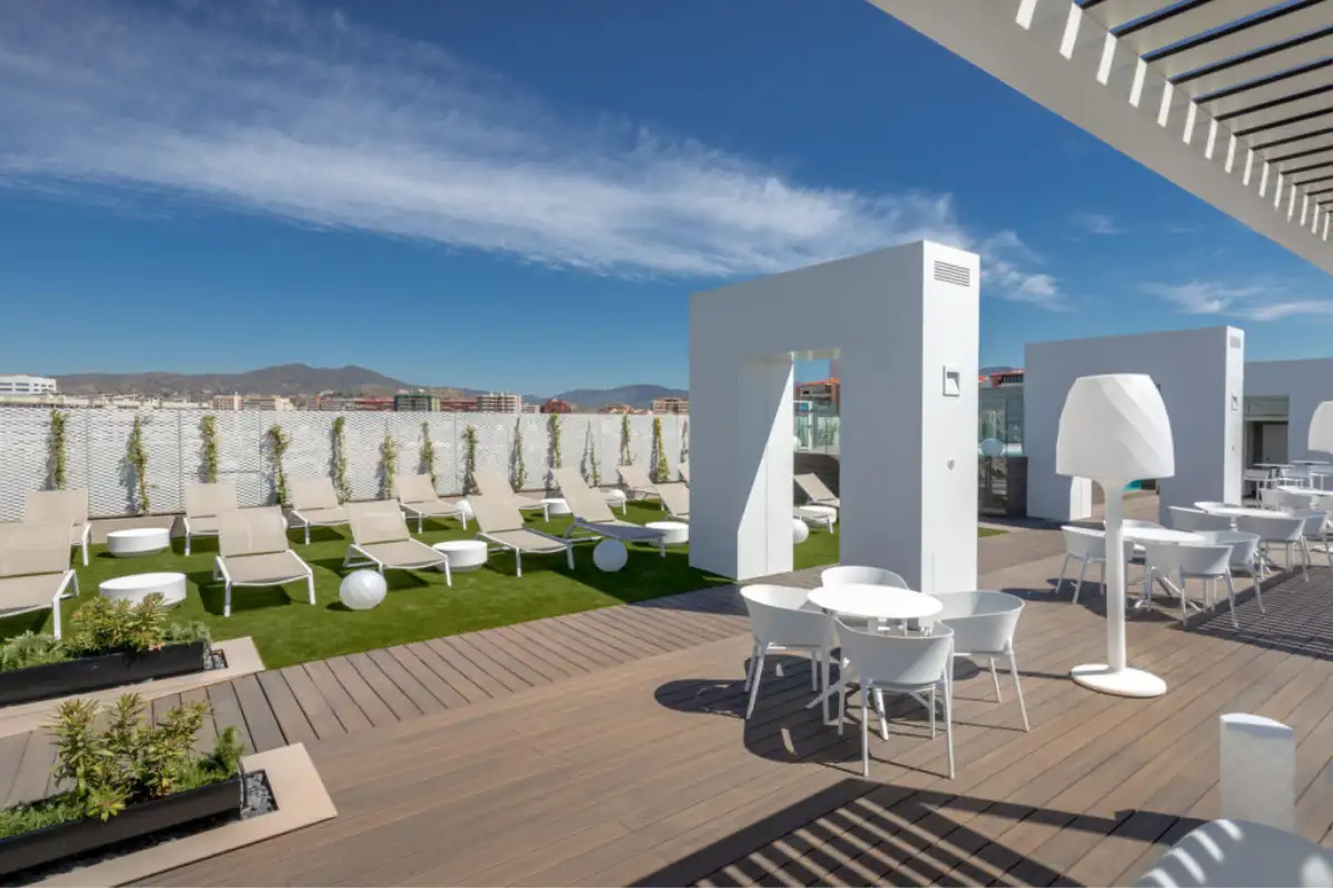 Rows of white sun loungers and ball lamps on the B-Heaven sundeck Malaga