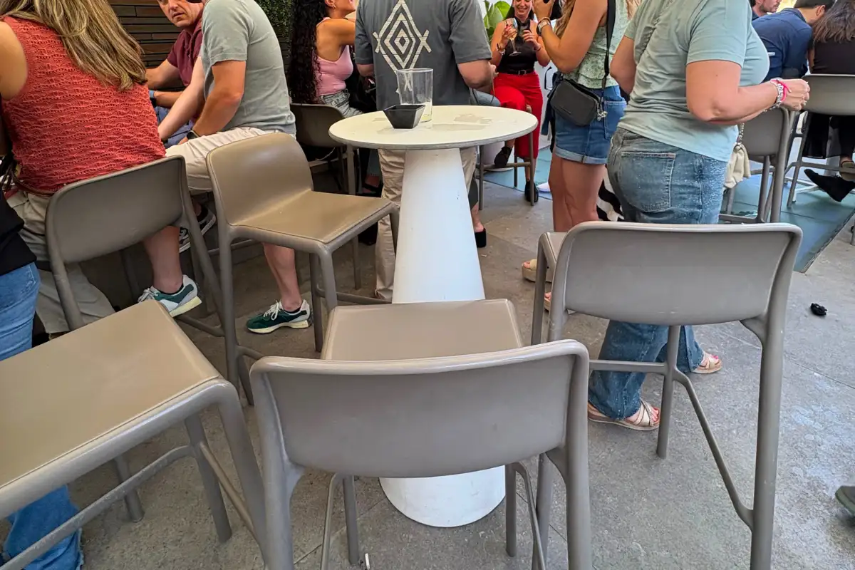 High bar tables and stools on the busy Chinitas Urban terrace in Malaga