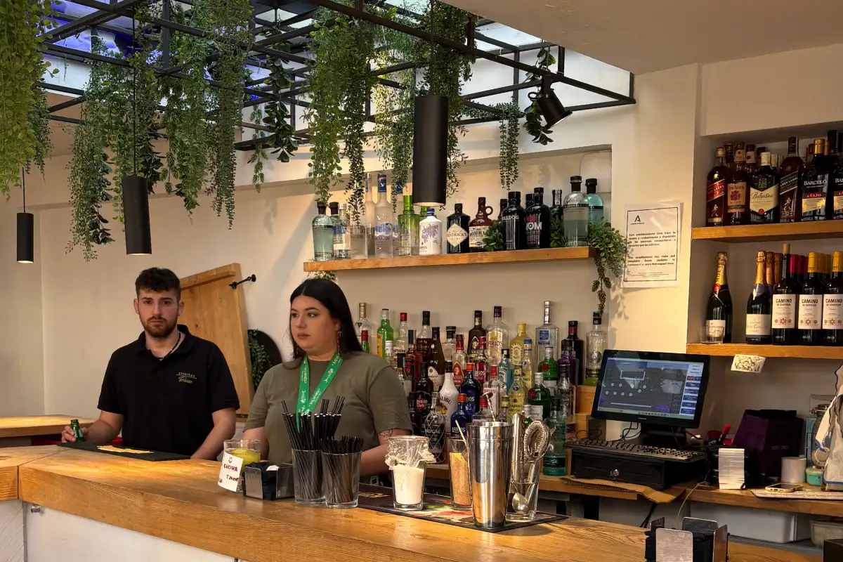 Staff behind the indoor cocktail bar with hanging plants at Chinitas Malaga