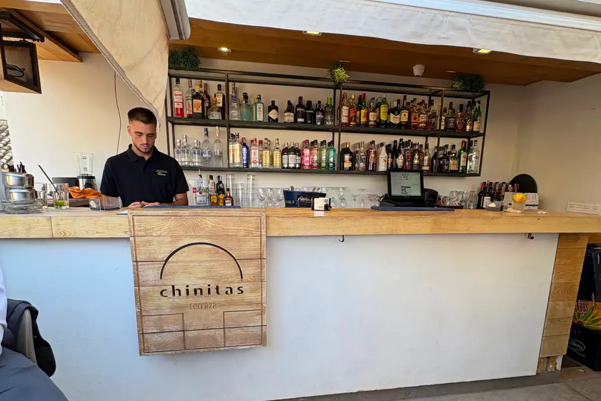 Bartender at the wooden rooftop bar counter at Chinitas Urban Malaga
