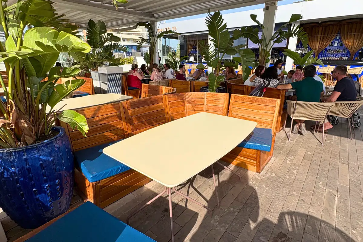 Blue-cushioned bench seating and tables on the Cobalto 15 terrace in Malaga