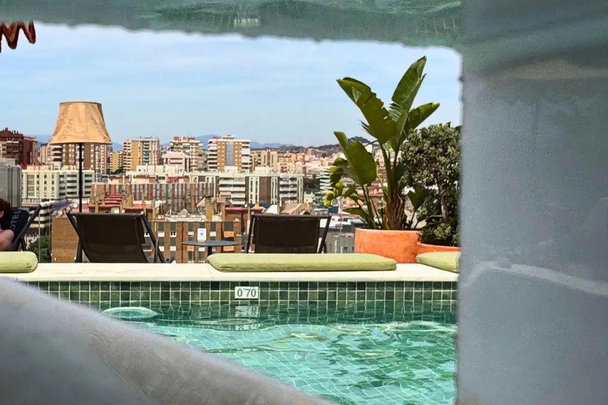 Sunloungers beside the pool with city views at H10 Croma, Malaga