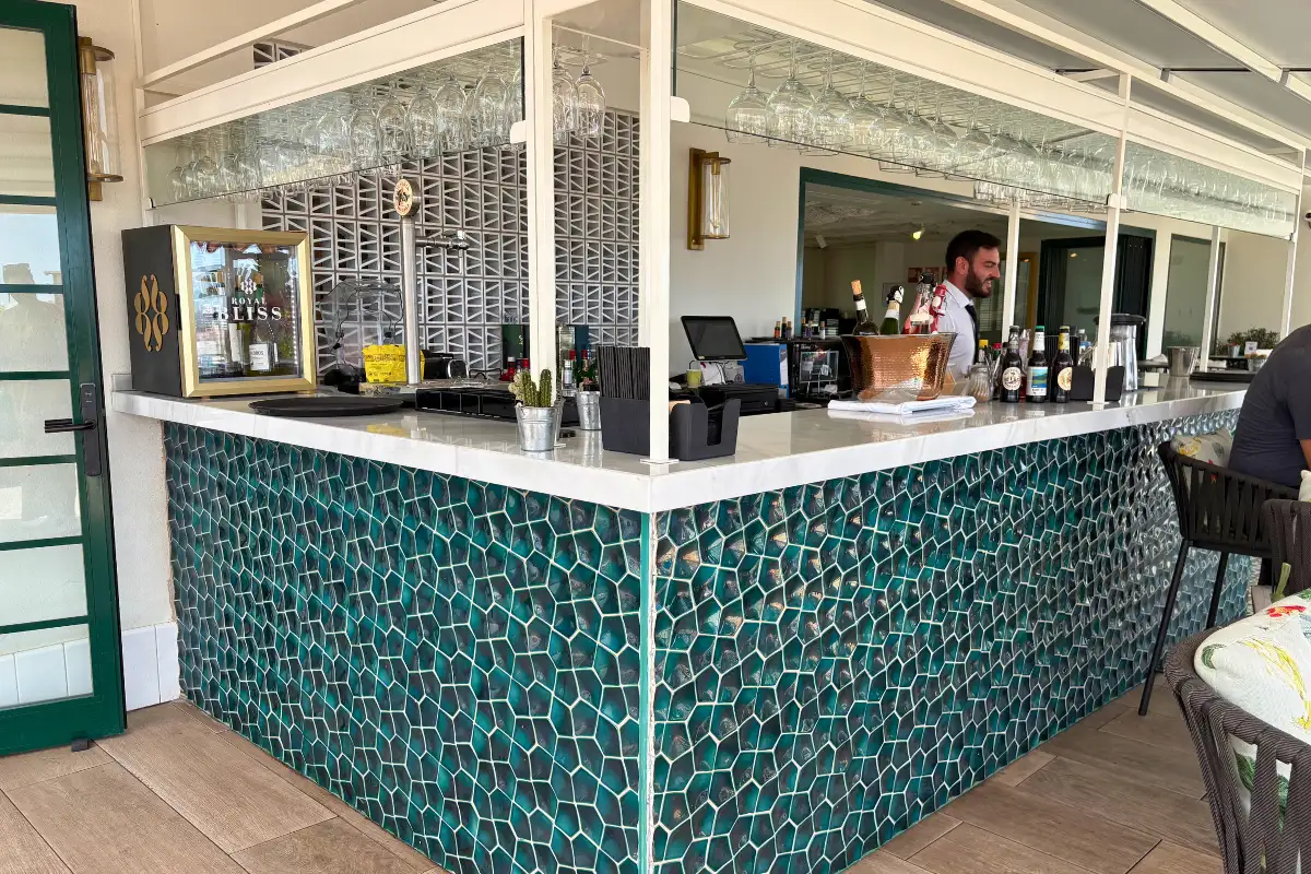 Green-tiled bar counter with bartender at H10 Croma rooftop, Malaga