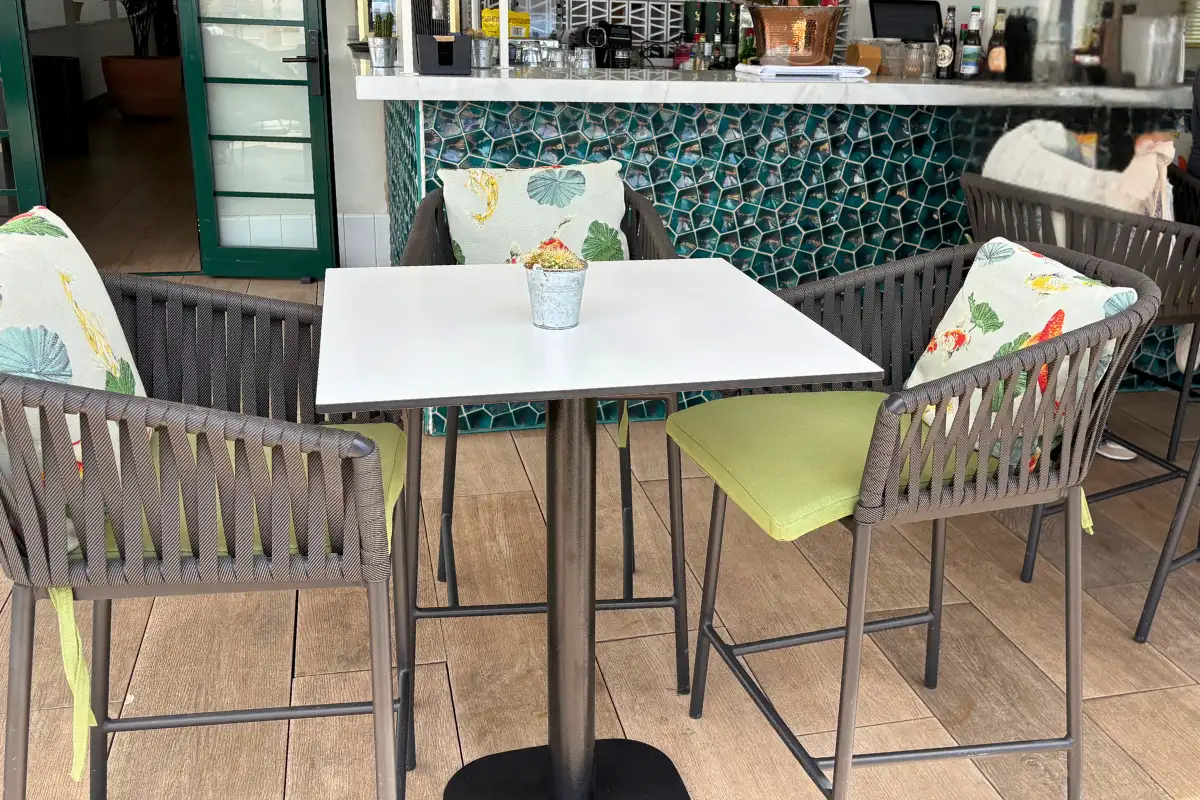 Dining table and chairs over patterned mosaic floor at H10 Croma, Malaga