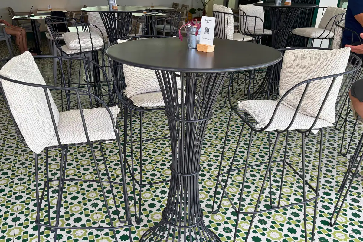 High tables and chairs on the patterned mosaic floor at H10 Croma, Malaga