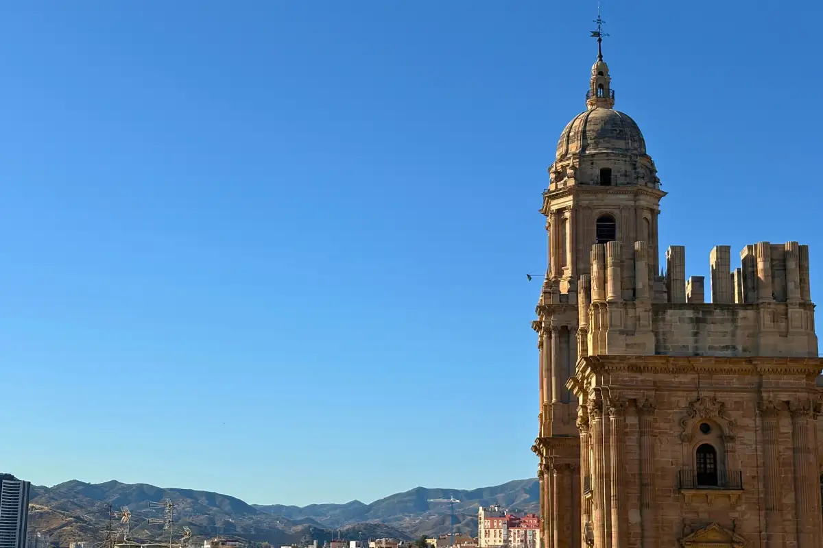 Malaga cathedral tower against hills seen from Molina Lario rooftop