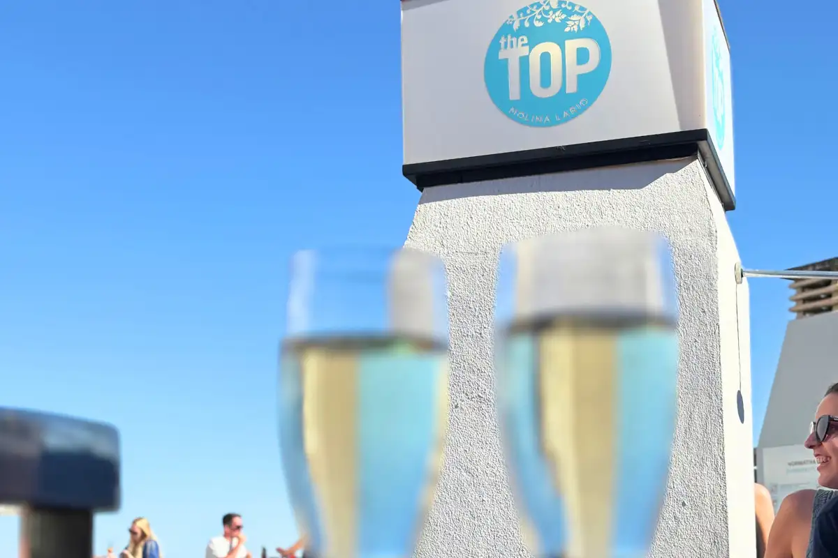 Two cava glasses beside the Top bar sign at Molina Lario rooftop, Malaga