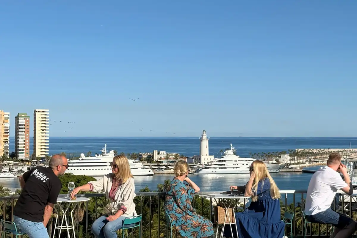 Guests at high tables with harbour views on Molina Lario rooftop, Malaga
