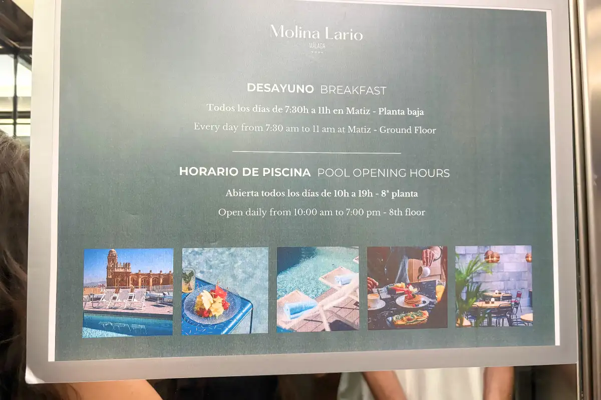 Breakfast and pool opening hours sign at Molina Lario rooftop, Malaga