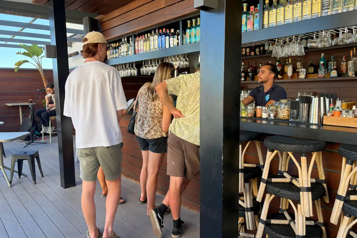 People ordering at the wooden rooftop cocktail bar at Hotel Molina Lario in Malaga