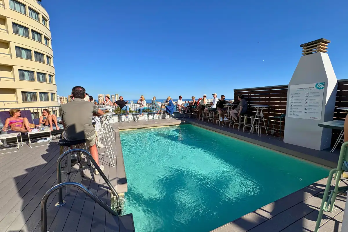 Rooftop swimming pool and bar with sunbathers at Hotel Molina Lario in Malaga