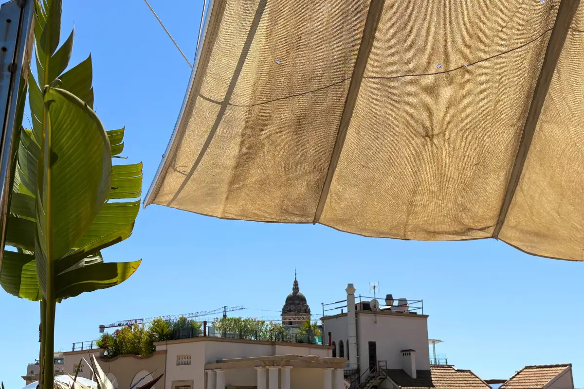 View of Malaga Cathedral dome past a sun awning at La Terraza de Alcazaba