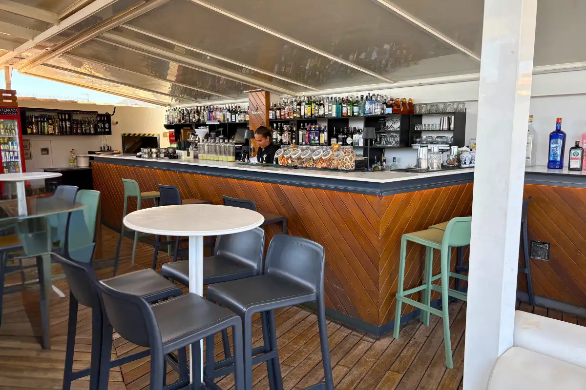 Wooden bar counter with stools under cover at La Terraza de Alcazaba in Malaga