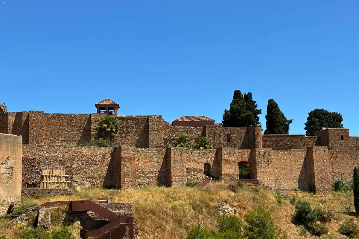 Ancient walls of the Alcazaba fortress under blue sky in Malaga
