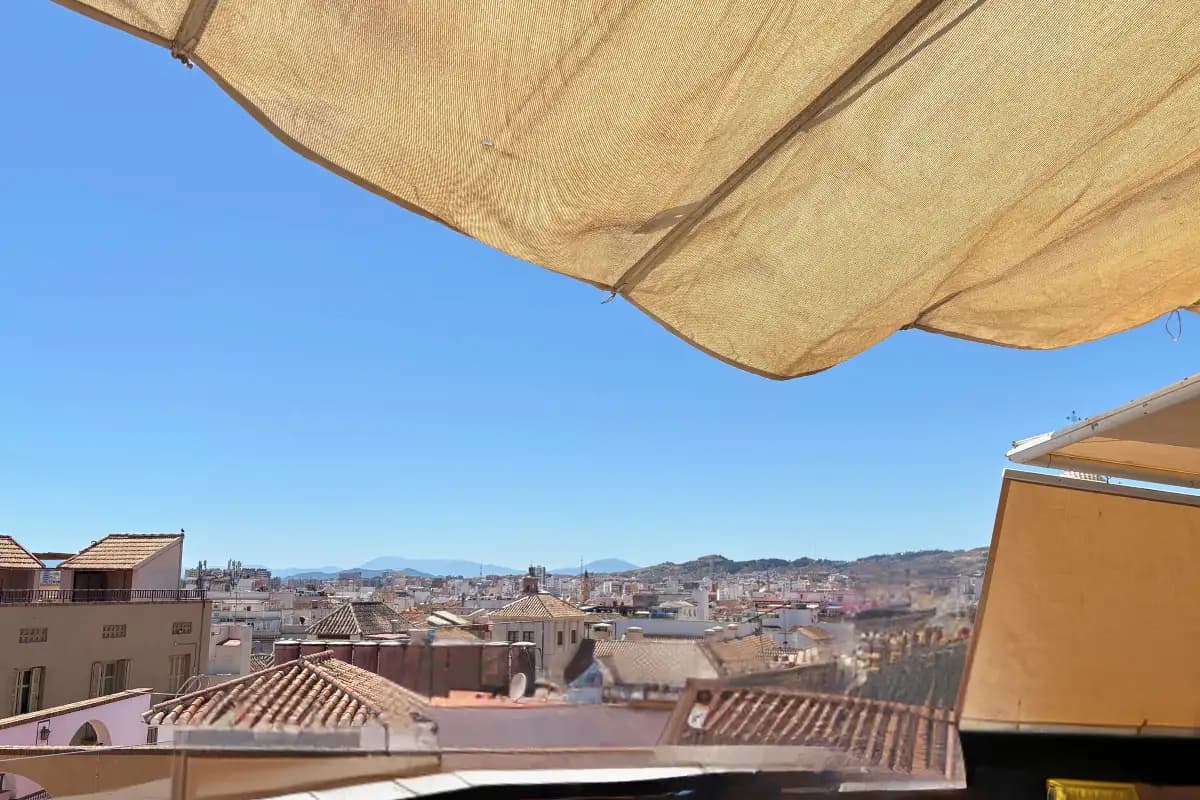 Shaded rooftop overlooking the Malaga city skyline at La Terraza de Alcazaba