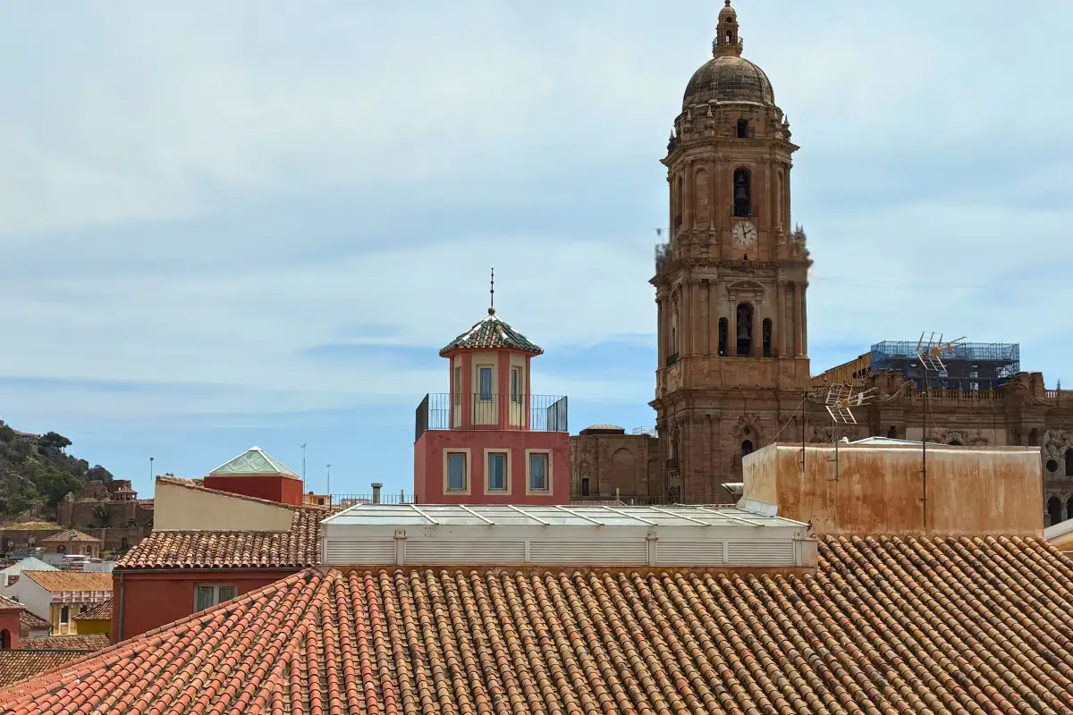 Malaga Cathedral tower rising above tiled rooftops from La Terraza de Larios