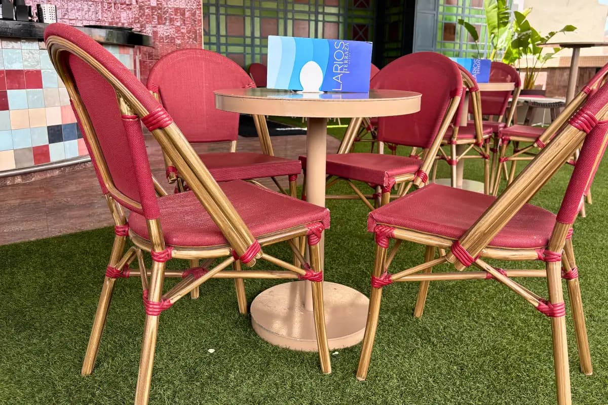 Red bistro chairs around dining tables at La Terraza de Larios in Malaga