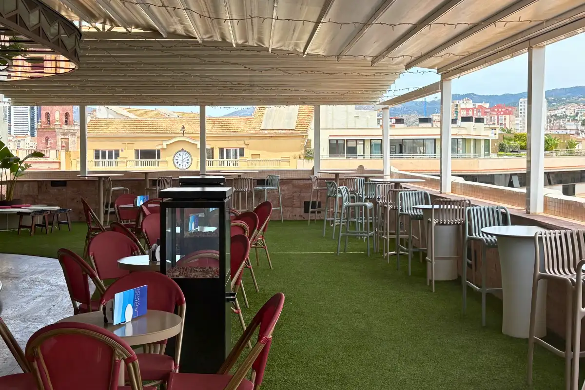 Red chairs and high tables on the covered terrace at La Terraza de Larios in Malaga