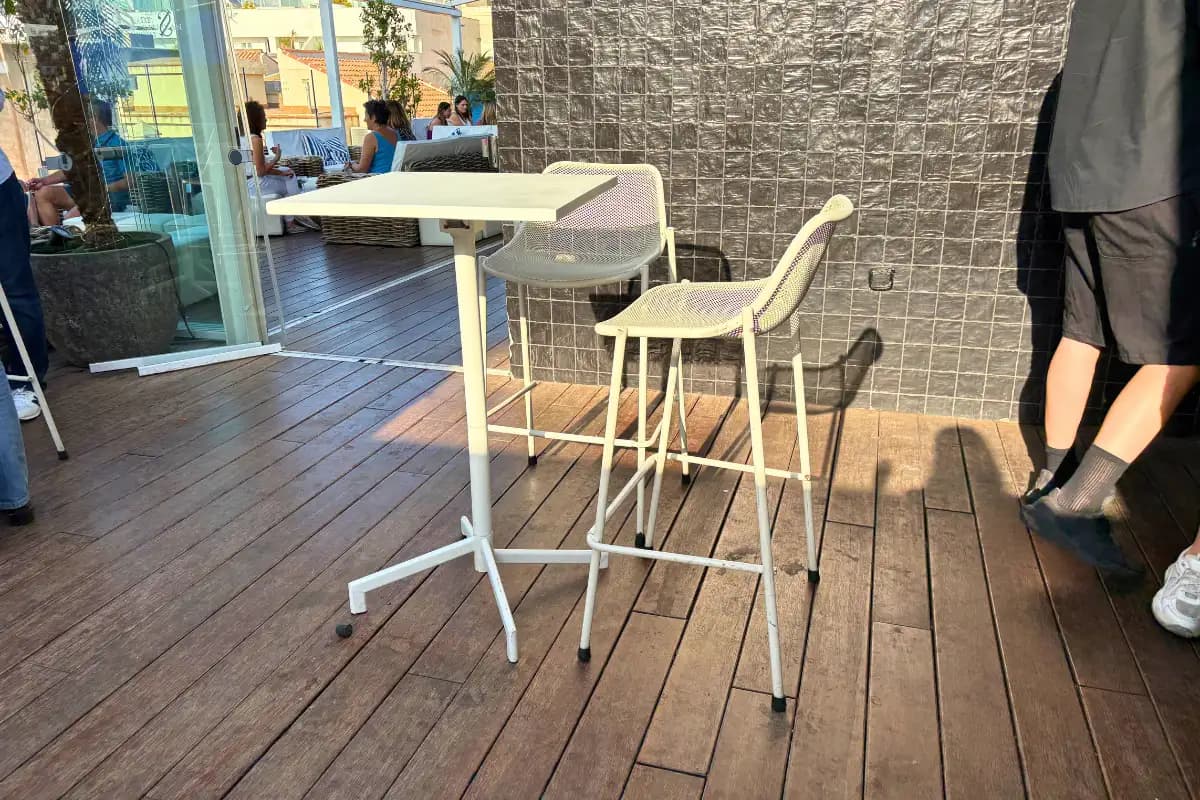 White high tables and bar stools on the deck at La Terraza de San Juan in Malaga