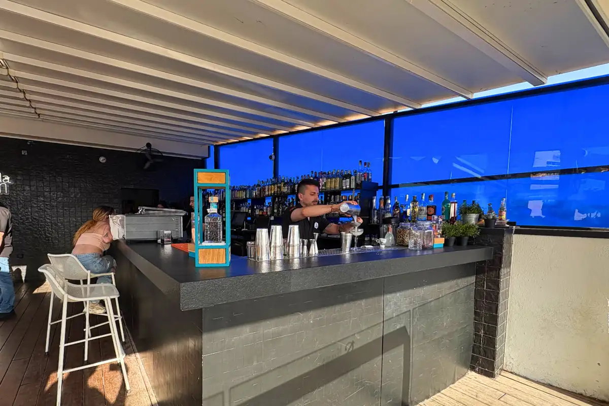 Bartender at the lit cocktail counter after dark at La Terraza de San Juan in Malaga