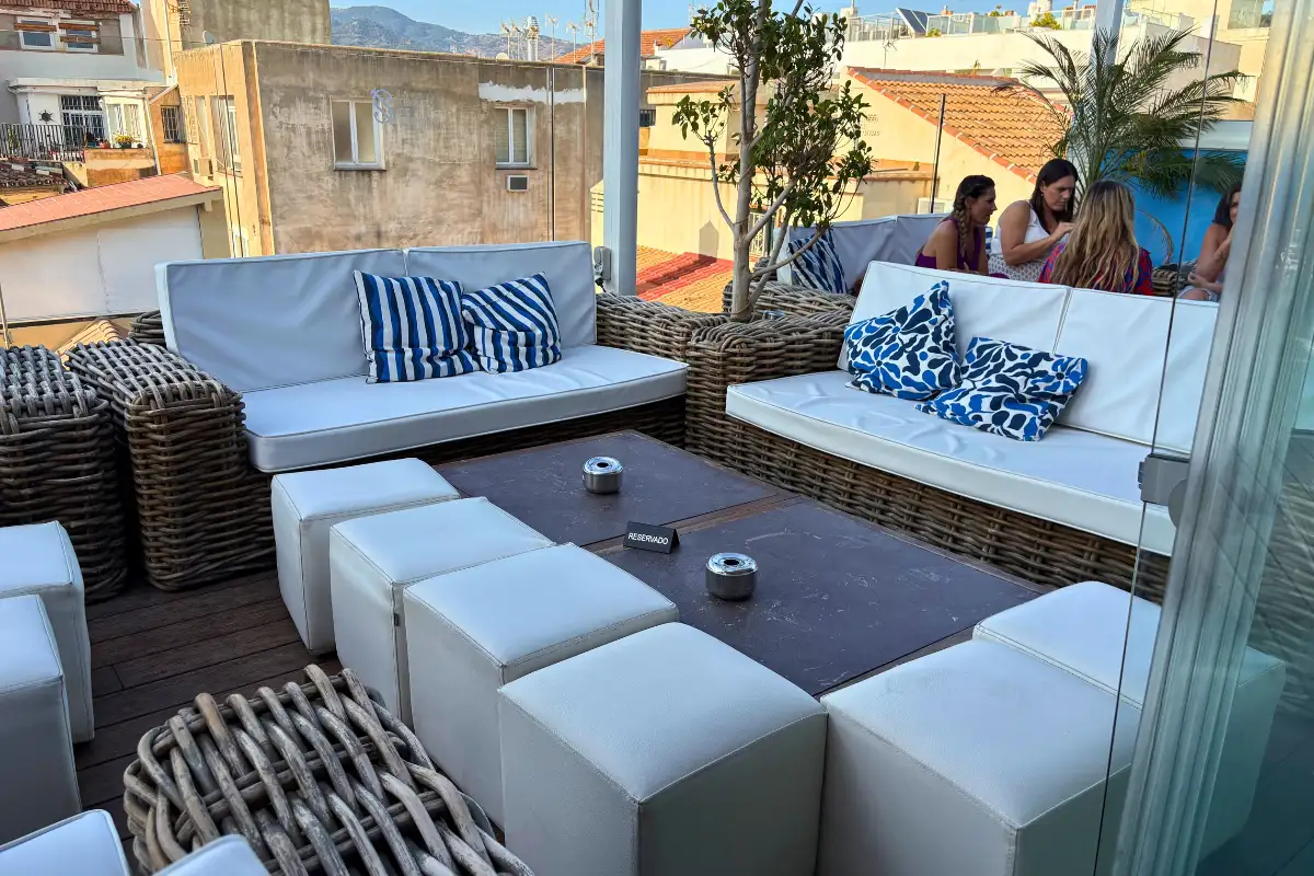 Wicker lounge sofas and cushioned stools on La Terraza de San Juan rooftop in Malaga