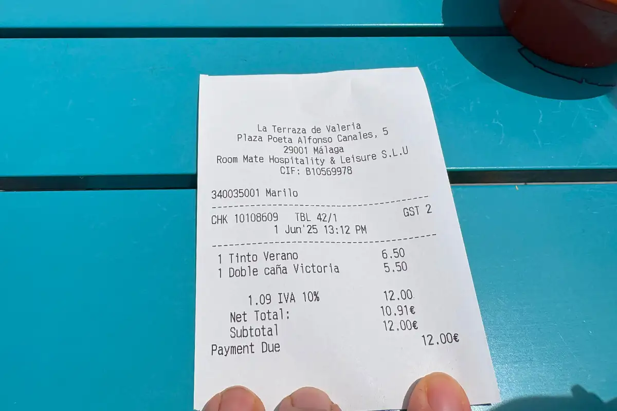Hand holding an itemised bill receipt at La Terraza de Valeria in Malaga