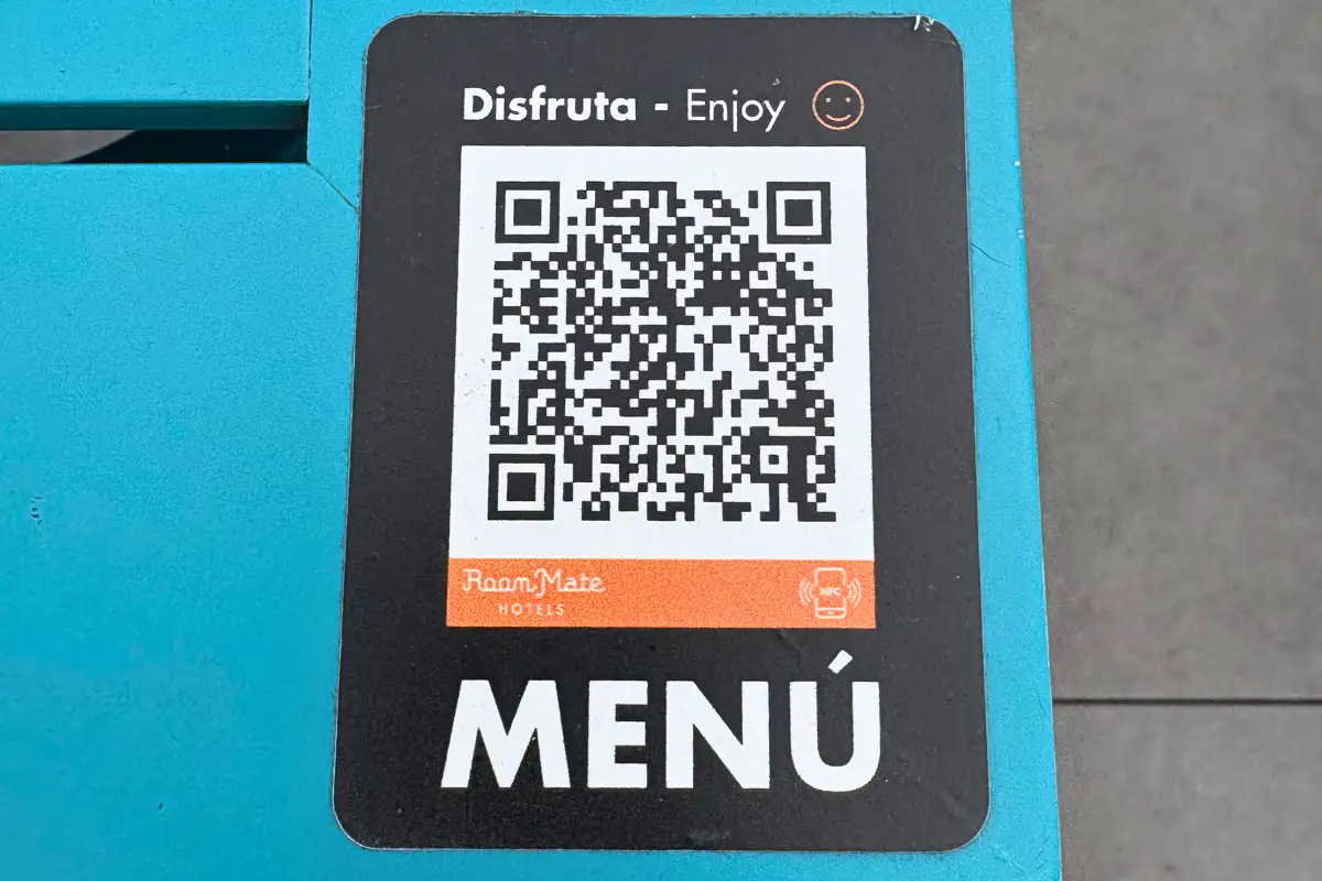 QR code menu sign on a turquoise surface at La Terraza de Valeria in Malaga