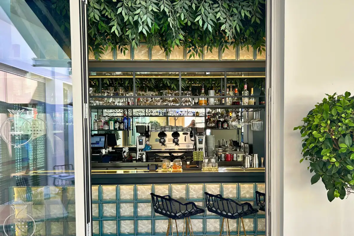 Glass-walled bar draped with greenery at La Terraza Solecio in Malaga