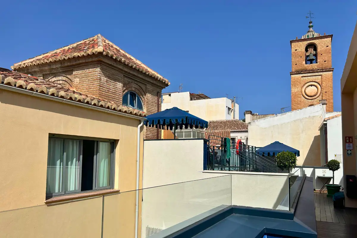 Cathedral tower and tiled roofs beyond the rooftop pool at La Terraza Solecio in Malaga