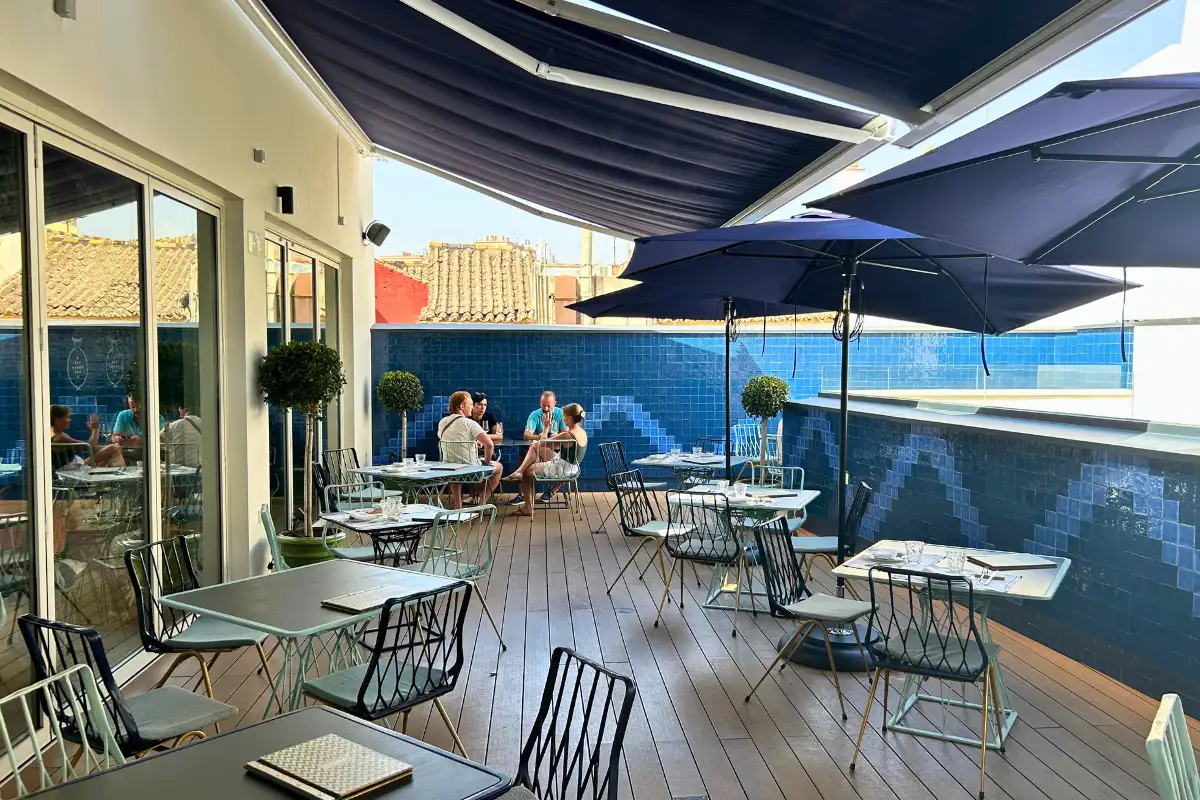 Decked dining terrace with navy parasols at La Terraza Solecio in Malaga