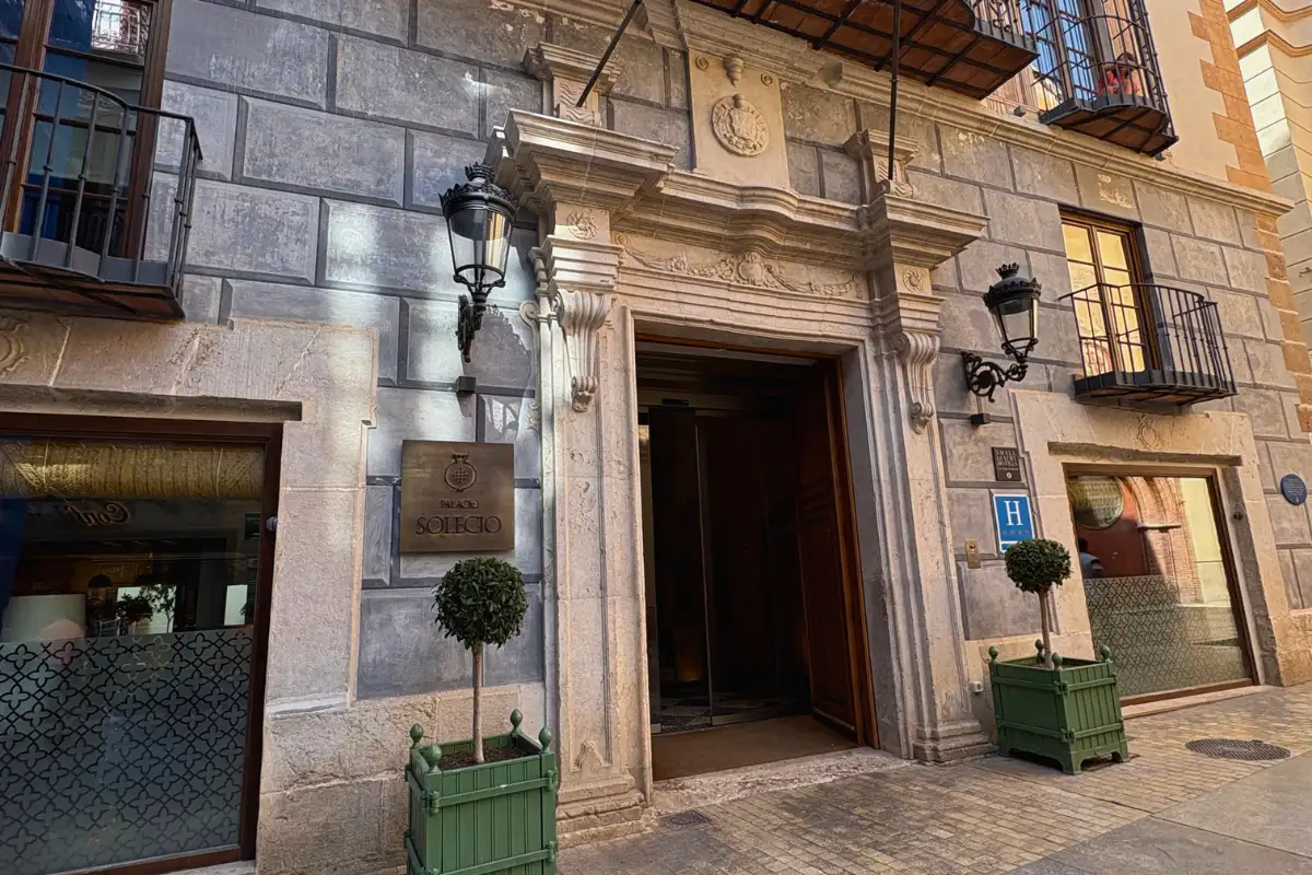 Stone facade and arched doorway of Palacio Solecio hotel in Malaga