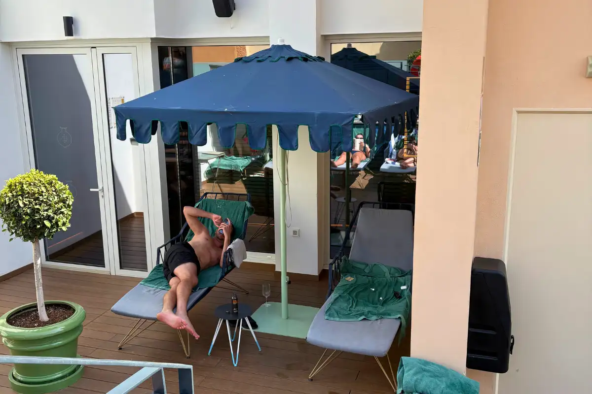 Sunbeds and a navy parasol beside the rooftop pool at Palacio Solecio in Malaga
