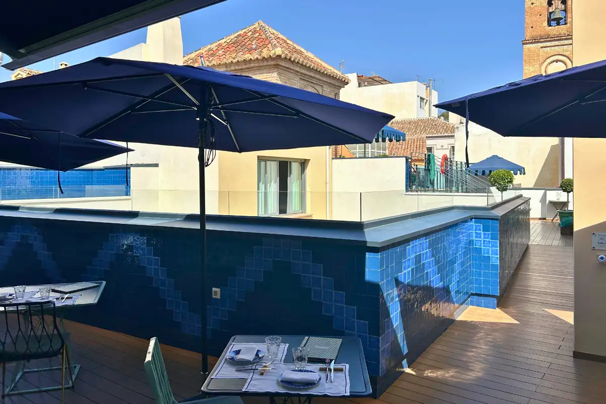 Rooftop pool terrace with parasols and cathedral view at La Terraza Solecio in Malaga