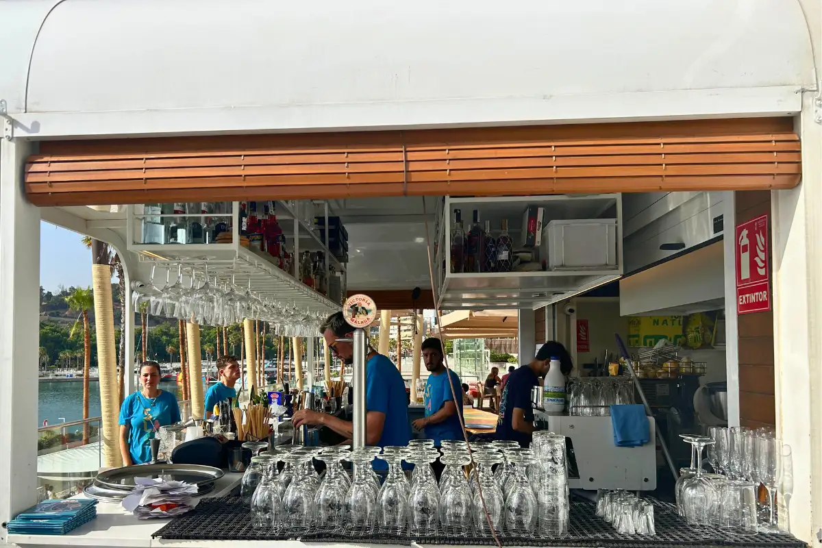 Staff behind the harbourside cocktail bar at La Terraza Surfera in Malaga