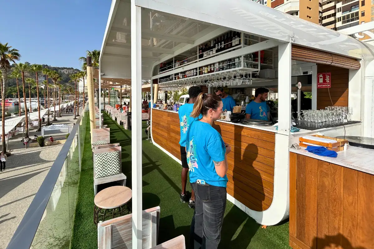 Promenade bar with staff and seafront walkway at La Terraza Surfera in Malaga