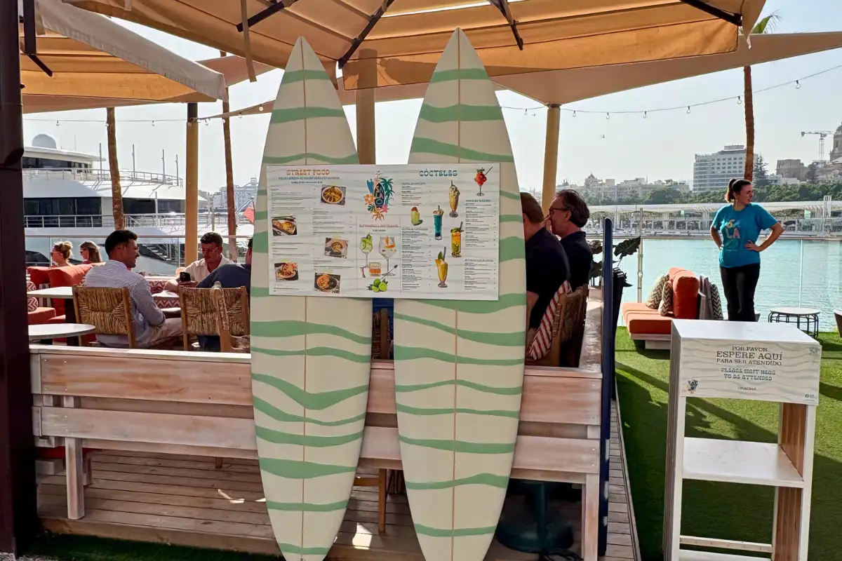 Decorated surfboards displayed on the waterfront terrace at La Terraza Surfera in Malaga