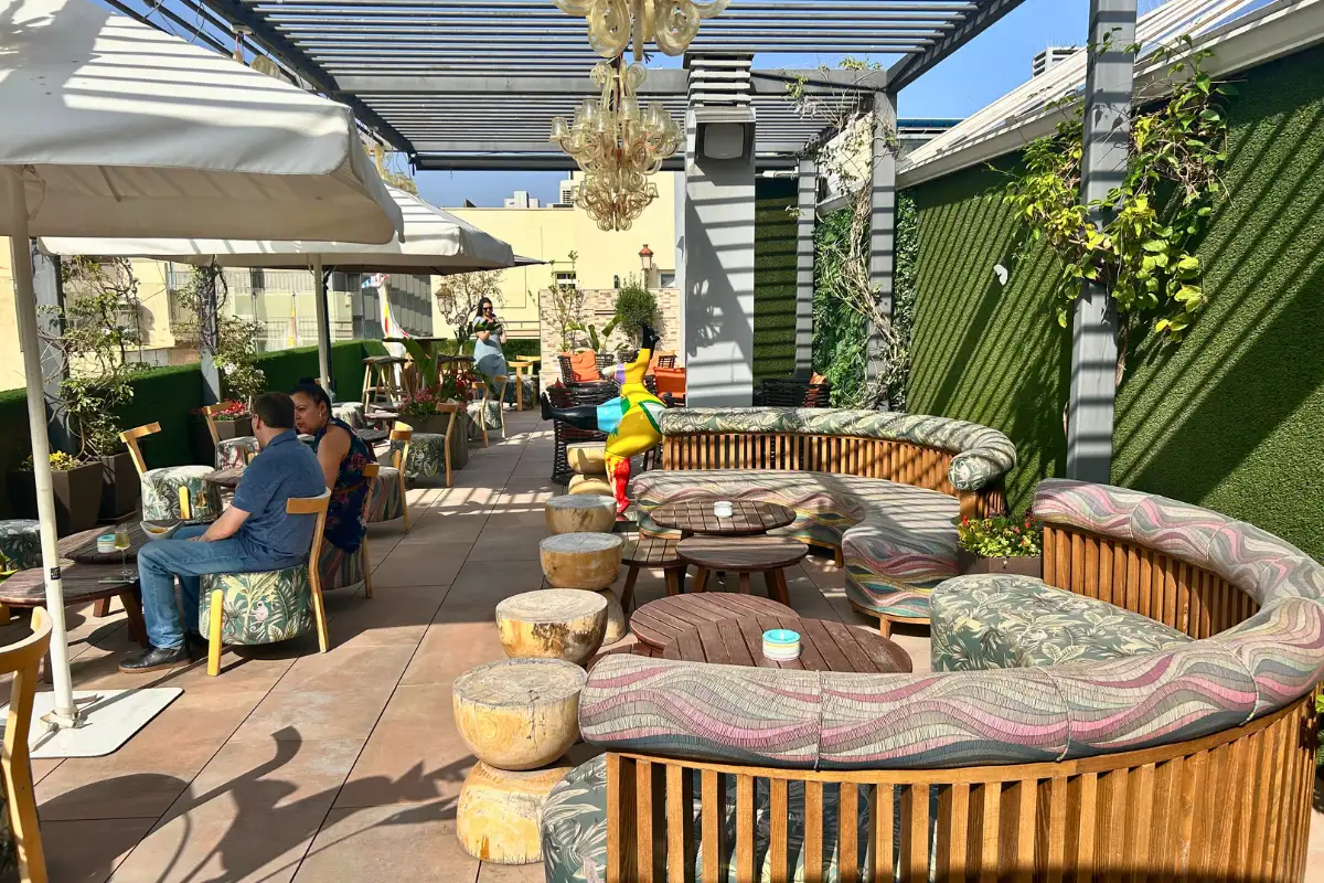 Curved lounge seating and greenery on the terrace at EFECTO Rooftop, Hotel Mariposa Malaga