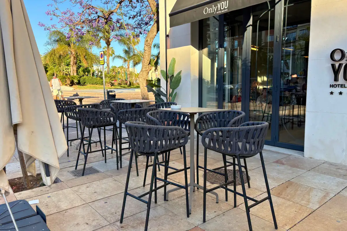 Black bar stools and high tables outside the entrance at Lolita Skyview in Malaga