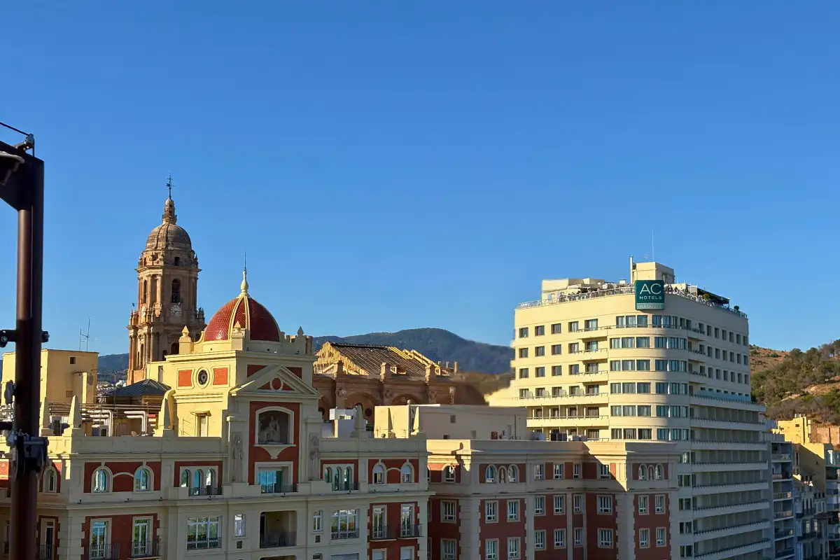 Malaga cathedral tower rising above rooftops seen from Lolita Skyview