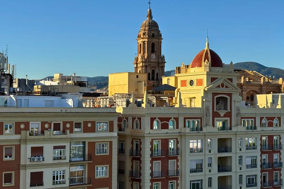 Malaga cathedral and old town rooftops under blue sky from Lolita Skyview