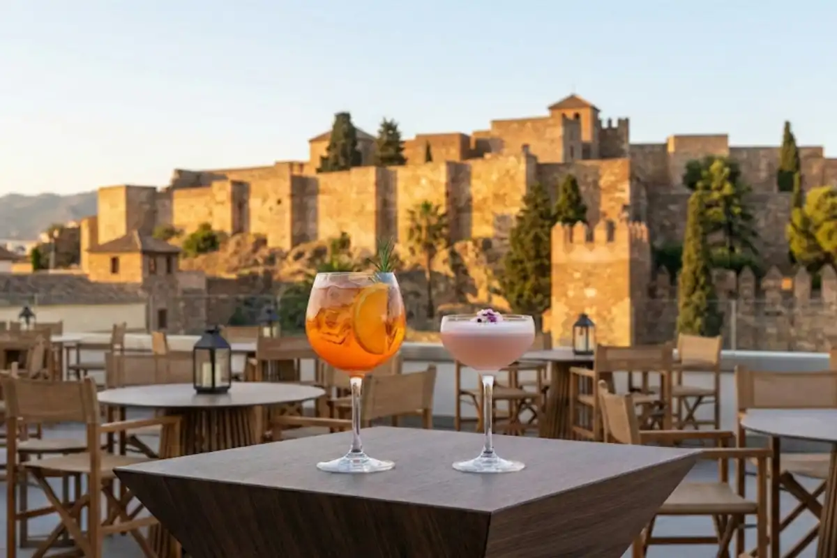Orange cocktail on a terrace table with the Alcazaba fortress behind at ME Malaga
