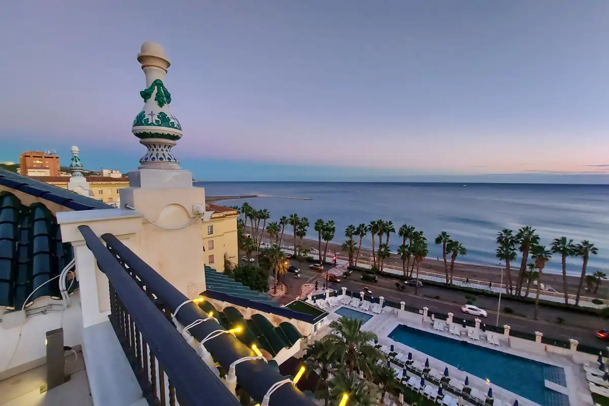 Terrace balustrade overlooking the pool and beach at dusk at Media Luna, Gran Hotel Miramar, Malaga